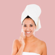 A woman with a towel on her head and smiling.