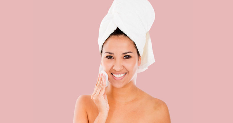 A woman with a towel on her head and smiling.